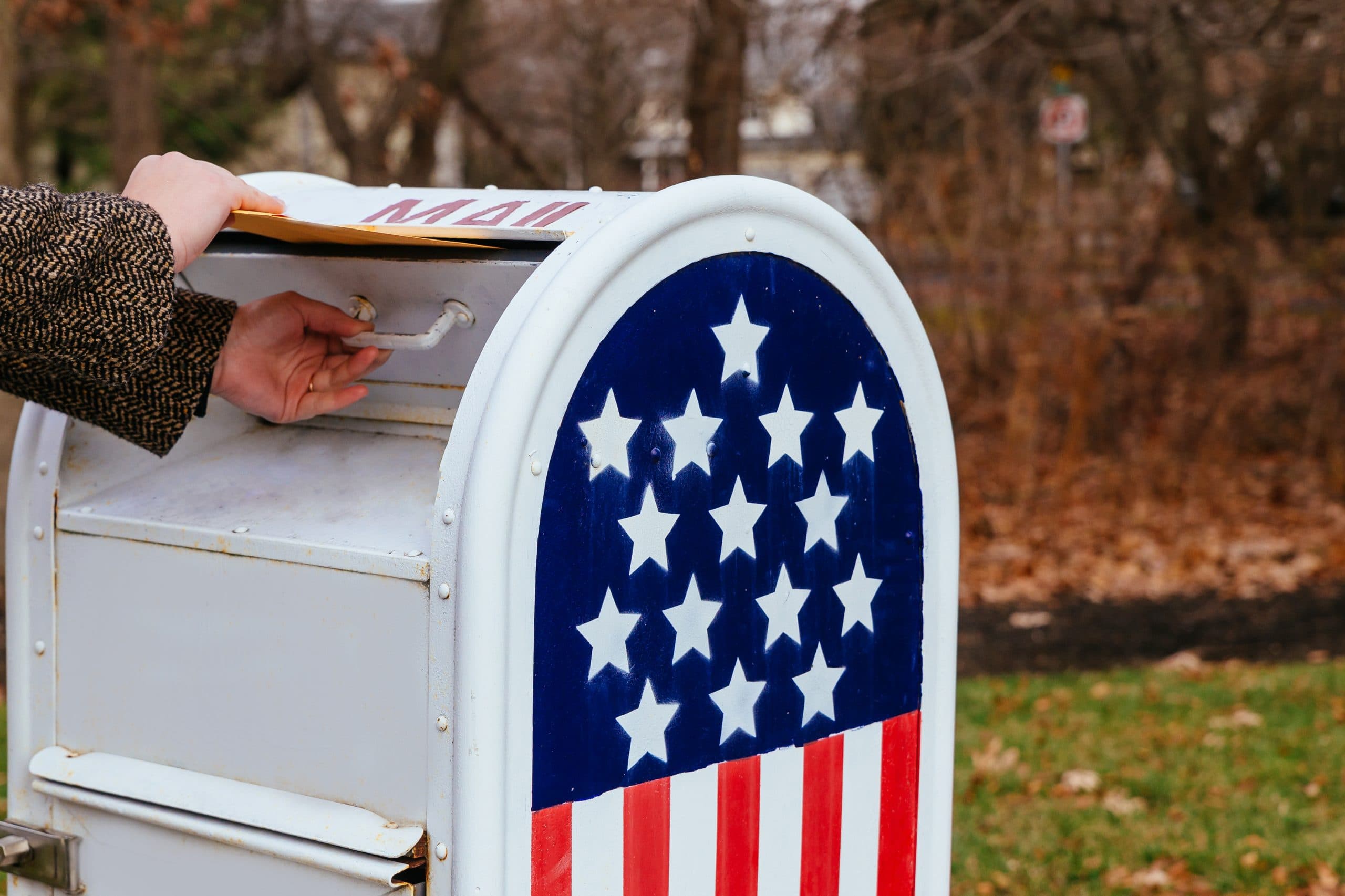 A person dropping off mail inside a mailbox. It would be easier if they used a virtual mailbox instead.