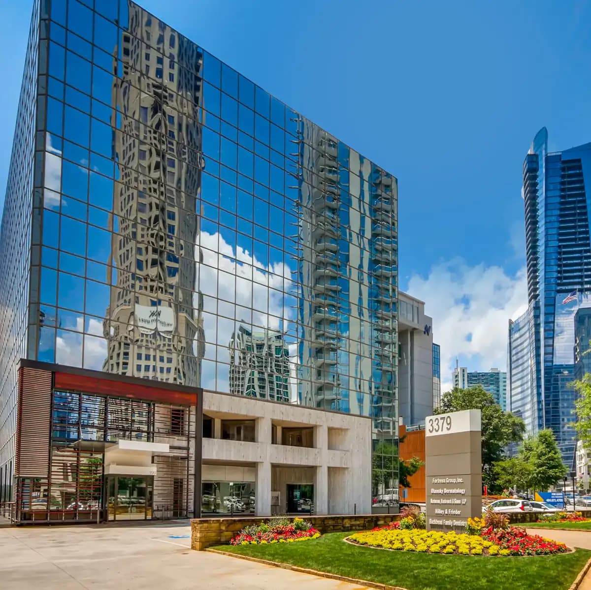 Exterior view of the Atlanta virtual office building at 3379 Peachtree Road NE, showcasing modern glass architecture and nearby high-rise buildings.