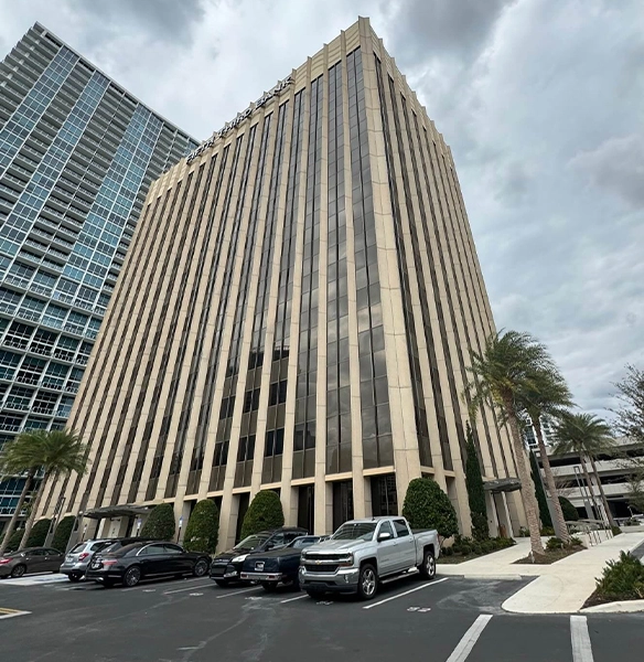Tall office building at 200 E Robinson Street, Orlando, FL, home to Opus Virtual Office, under a cloudy sky.
