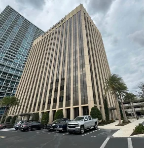 Tall office building at 200 E Robinson Street, Orlando, FL, home to Opus Virtual Office, under a cloudy sky.